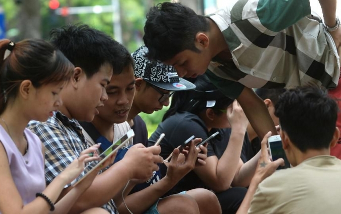 Forbes - People use tablets and smartphones at a public park next to Hoan Kiem Lake in the center of Hanoi on August 10, 2016. (Photo: HOANG DINH NAM/AFP/Getty Images)